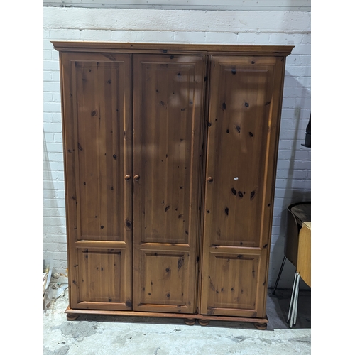 55A - A large pine triple wardrobe, 138cm x 56cm x 180cm