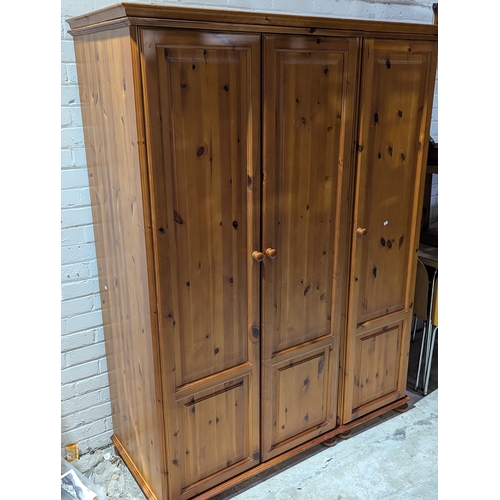 55A - A large pine triple wardrobe, 138cm x 56cm x 180cm