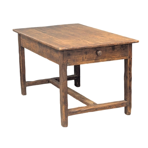 31 - An Early 19th Century French pine and fruitwood farmhouse kitchen table with drawer and stretcher ba... 