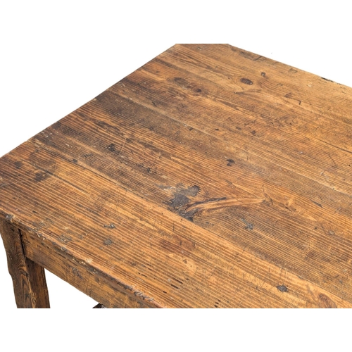 31 - An Early 19th Century French pine and fruitwood farmhouse kitchen table with drawer and stretcher ba... 