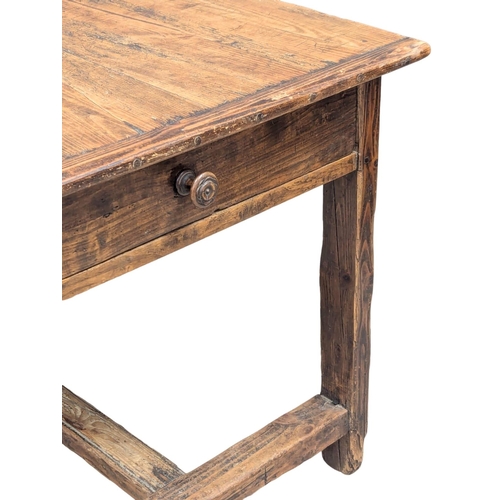 31 - An Early 19th Century French pine and fruitwood farmhouse kitchen table with drawer and stretcher ba... 