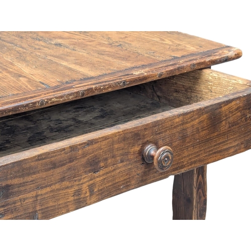 31 - An Early 19th Century French pine and fruitwood farmhouse kitchen table with drawer and stretcher ba... 