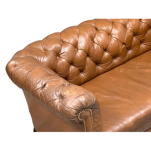 4 - A 19th Century Victorian deep button leather Chesterfield sofa, on turned mahogany legs. Circa 1880.... 