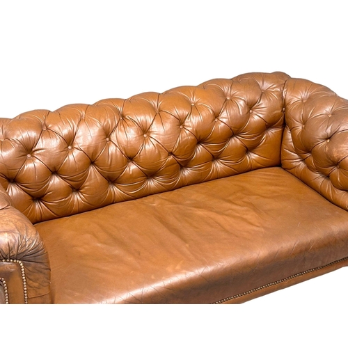 4 - A 19th Century Victorian deep button leather Chesterfield sofa, on turned mahogany legs. Circa 1880.... 