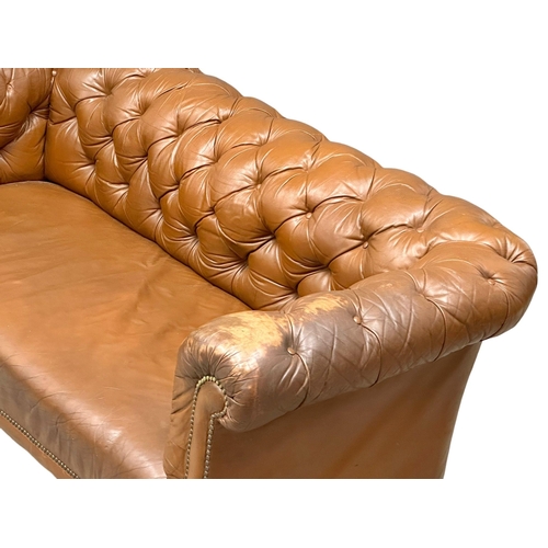 4 - A 19th Century Victorian deep button leather Chesterfield sofa, on turned mahogany legs. Circa 1880.... 