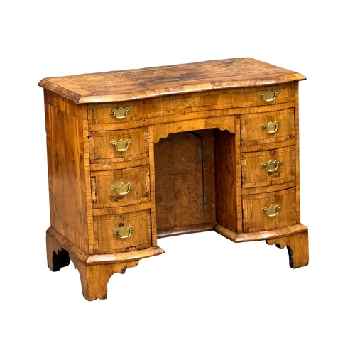 5 - An Early 18th Century, George I figured walnut kneehole desk. George I (1714-1727) with original bra... 