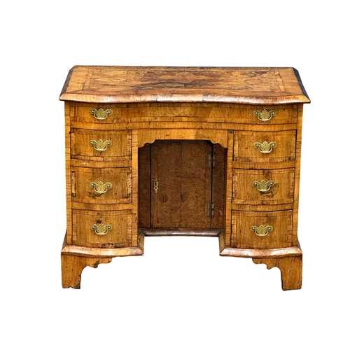 5 - An Early 18th Century, George I figured walnut kneehole desk. George I (1714-1727) with original bra... 