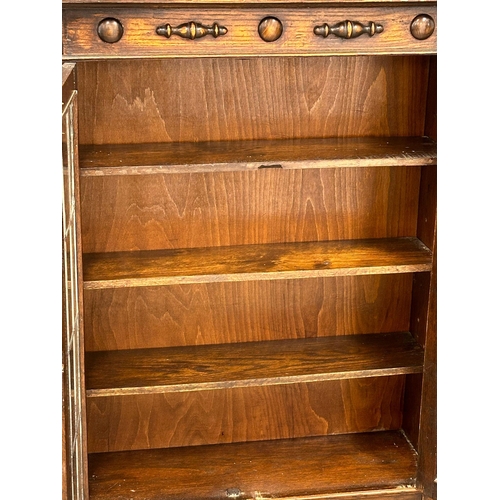 783 - An Early 20th Century oak bookcase with astragal glazed doors and adjustable shelves. In the Jacobea... 