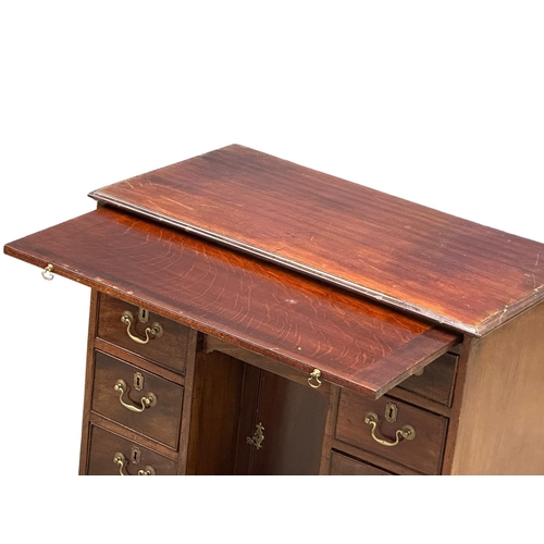 94 - An 18th Century George III mahogany kneehole desk. With original brass handles and brushing slide. C... 