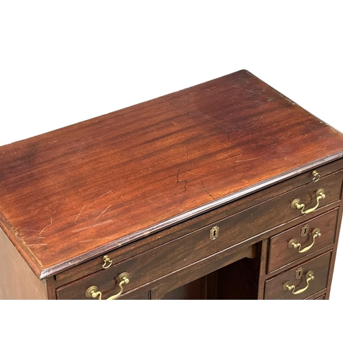 94 - An 18th Century George III mahogany kneehole desk. With original brass handles and brushing slide. C... 