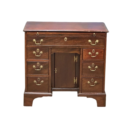 94 - An 18th Century George III mahogany kneehole desk. With original brass handles and brushing slide. C... 