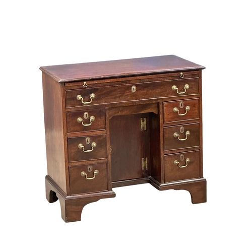 94 - An 18th Century George III mahogany kneehole desk. With original brass handles and brushing slide. C... 