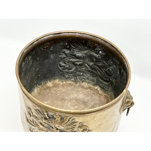 509 - A 19th Century Victorian embossed brass log bin/coal bucket with lion mask ring handles. 35x30x28cm