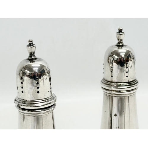 590 - A pair of large silver condiments/salt and pepper shakers. Stamped Sterling. 193g. 14cm