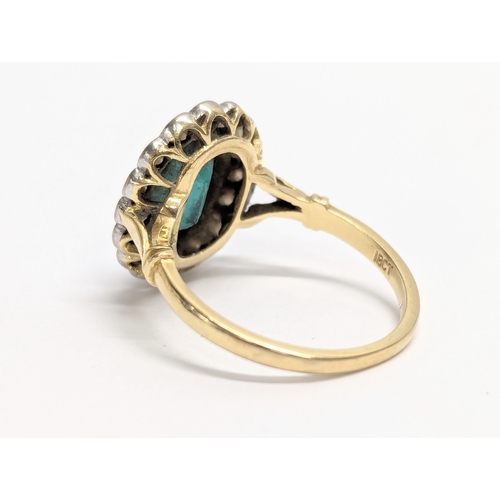 618 - An 18ct gold statement ring with an oval cut emerald and surrounding diamonds. Total weight 4g. Ring... 