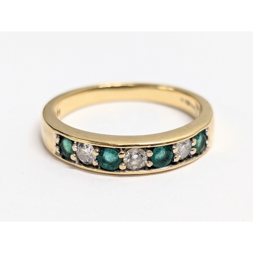 628 - An 18ct gold eternity ring with 4 emeralds and 3 diamonds. Total weight 3g. UK size N