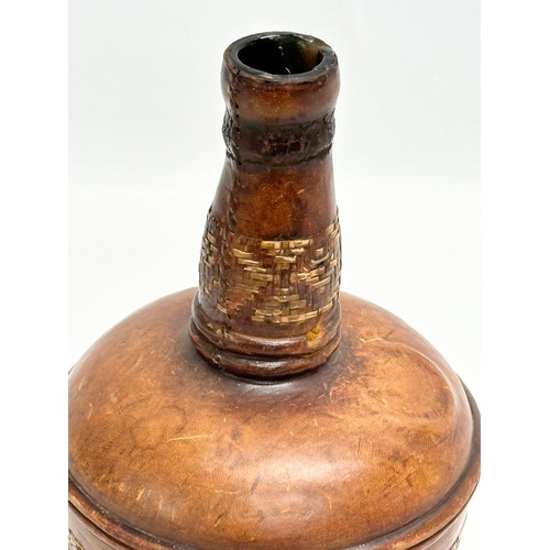 394 - A 19th Century glass and leather bound decanter flask. 12x22cm.