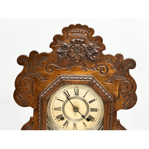 839 - A Late 19th Century gingerbread clock. With key and pendulum. 57cm