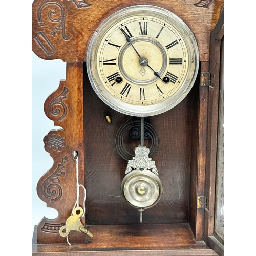 839 - A Late 19th Century gingerbread clock. With key and pendulum. 57cm