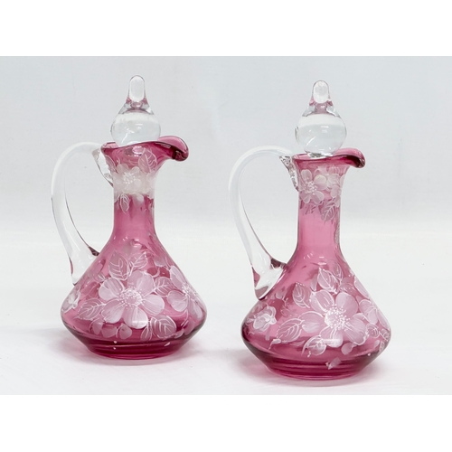 465 - A pair of Early 20th Century painted cranberry glass cruets. 17cm