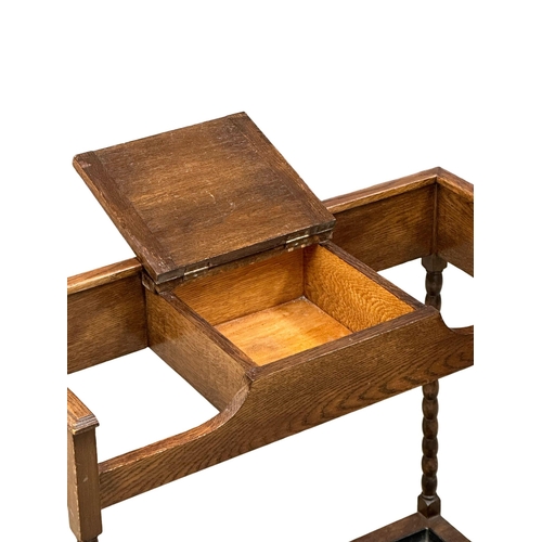 945 - An Early 20th Century oak umbrella stick stand. Circa 1920. 77x32.5x73.5cm (9)