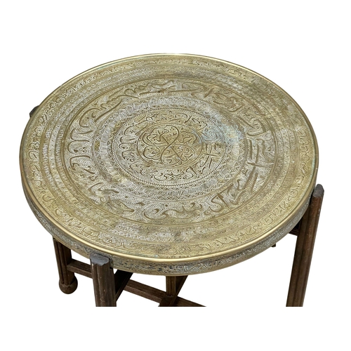 887 - An Early 20th Century brass top folding games table. 60x60x65cm