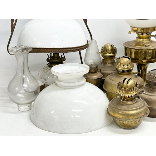 739 - A large collection of oil lamps, shades and funnels.