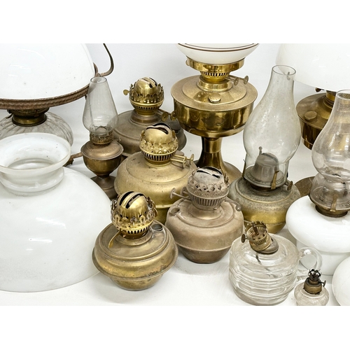 739 - A large collection of oil lamps, shades and funnels.