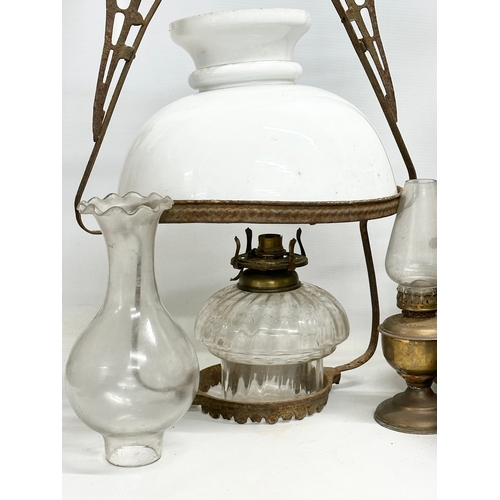 739 - A large collection of oil lamps, shades and funnels.