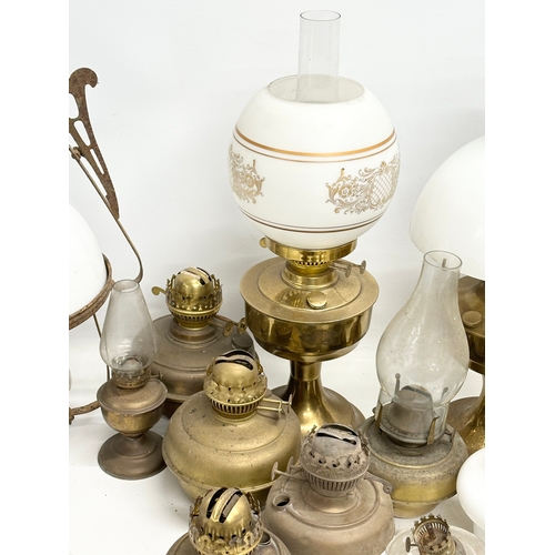 739 - A large collection of oil lamps, shades and funnels.