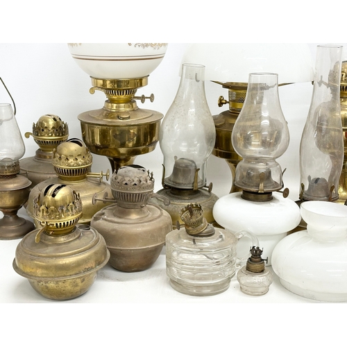 739 - A large collection of oil lamps, shades and funnels.