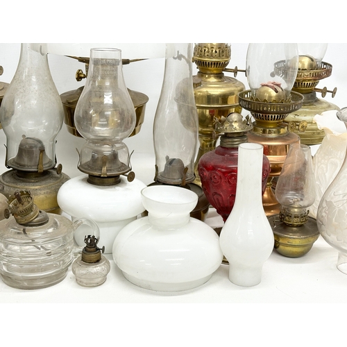 739 - A large collection of oil lamps, shades and funnels.