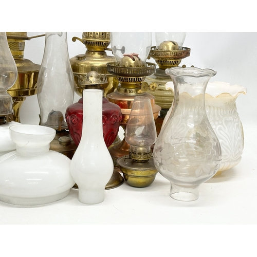 739 - A large collection of oil lamps, shades and funnels.