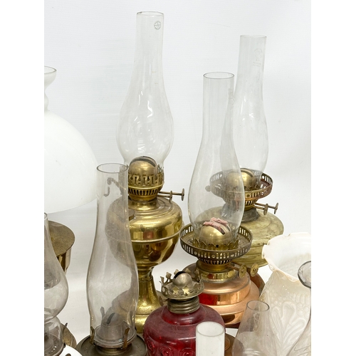 739 - A large collection of oil lamps, shades and funnels.