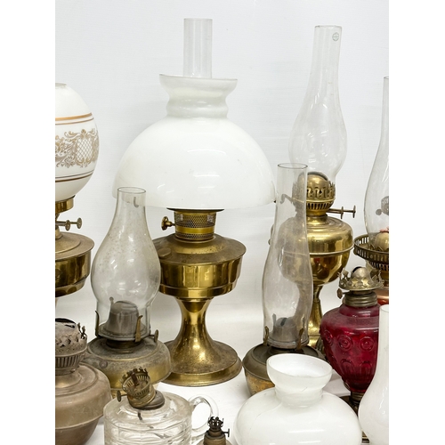 739 - A large collection of oil lamps, shades and funnels.