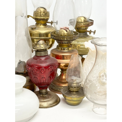 739 - A large collection of oil lamps, shades and funnels.