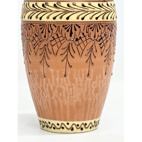 715B - A terracotta vase with lustre glazed interior and embossed enamel paintwork. 25cm