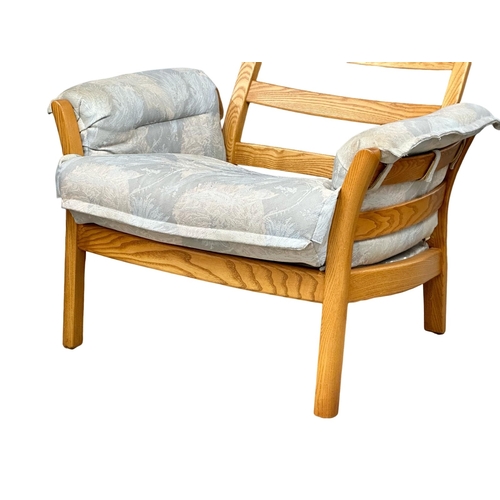 522 - A pair of Ercol blonde elm “Saville” armchairs.