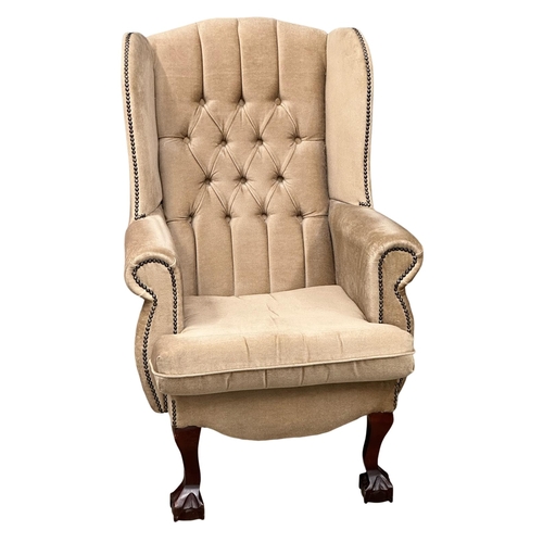 825 - A pair of deep button wingback armchairs.