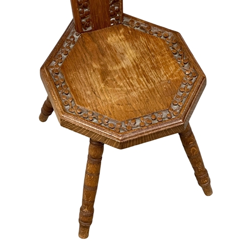 855 - An Early 20th Century oak spinning wheel chair with carved shamrock motif. 2