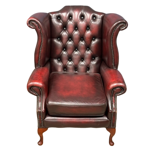 541A - A deep button ox blood leather wingback armchair.