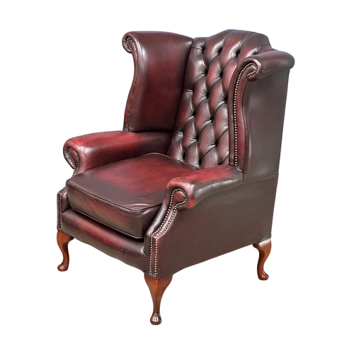 541A - A deep button ox blood leather wingback armchair.