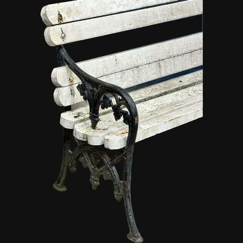 555A - A Late 19th Century Victorian garden bench with cast iron ends and wooden straps. 198cm