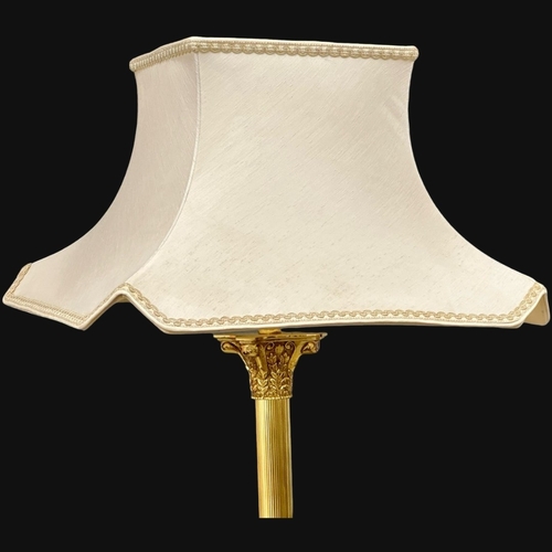 555B - A brass standard lamp with Corinthian style column and lion paw feet. 167cm