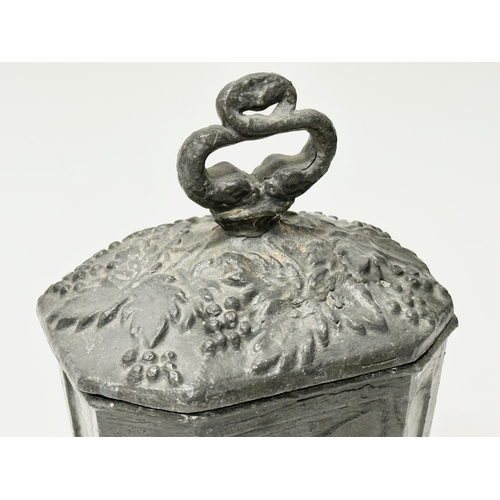 312 - An Early 19th Century English George III lead tobacco box. Depicting smokers pipes, four griffin fee... 