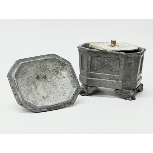 312 - An Early 19th Century English George III lead tobacco box. Depicting smokers pipes, four griffin fee... 