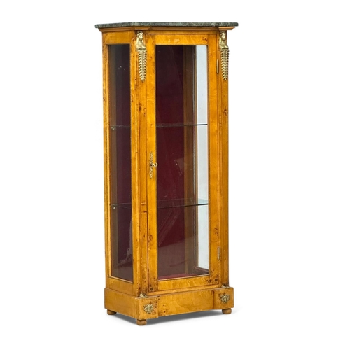 A Regency style birdseye maple display cabinet. With Egyptian brass mounts, breakfront and marble top, 2 glass shelves and red velvet interior. 65x45x143cm.