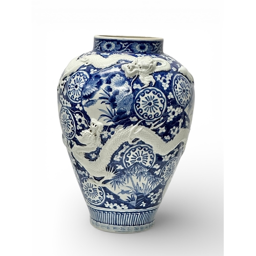 59 - An extra large Japanese Arita pot. Meiji Period (1868-1912) Late 19th Century. Two moulded relief dr... 