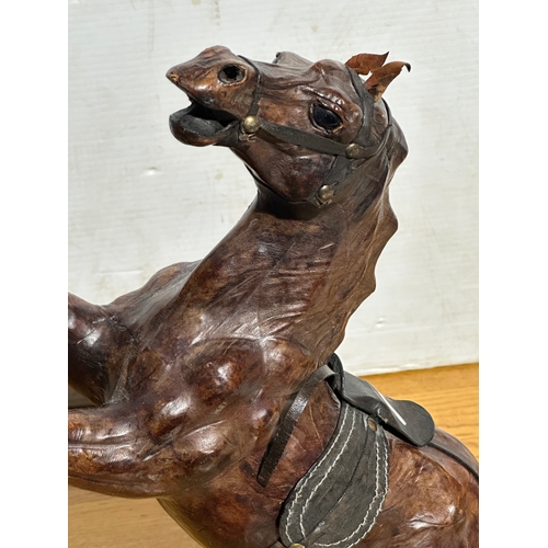 14 - A large leather rearing horse. 46cm.