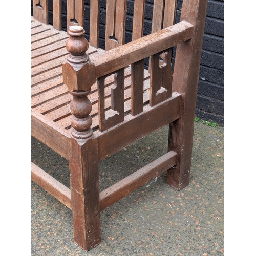 8 - A large Arts & Crafts style teak garden bench. 183x108cm